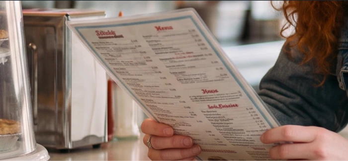 Cropped detail of the diner menu in the generated image, every printed line dissolving into nonsense letters
